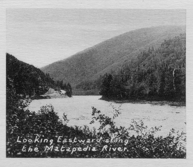 Black and white photograph of the Matapedia River that descends the Matapedia Valley winding between the mountains and forest of evergreen trees.