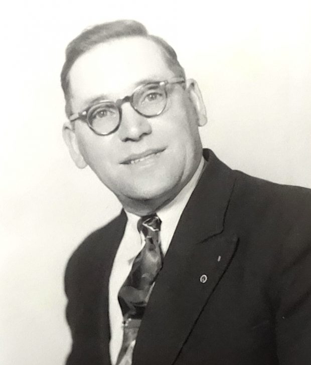 A man with glasses wearing a suit and tie