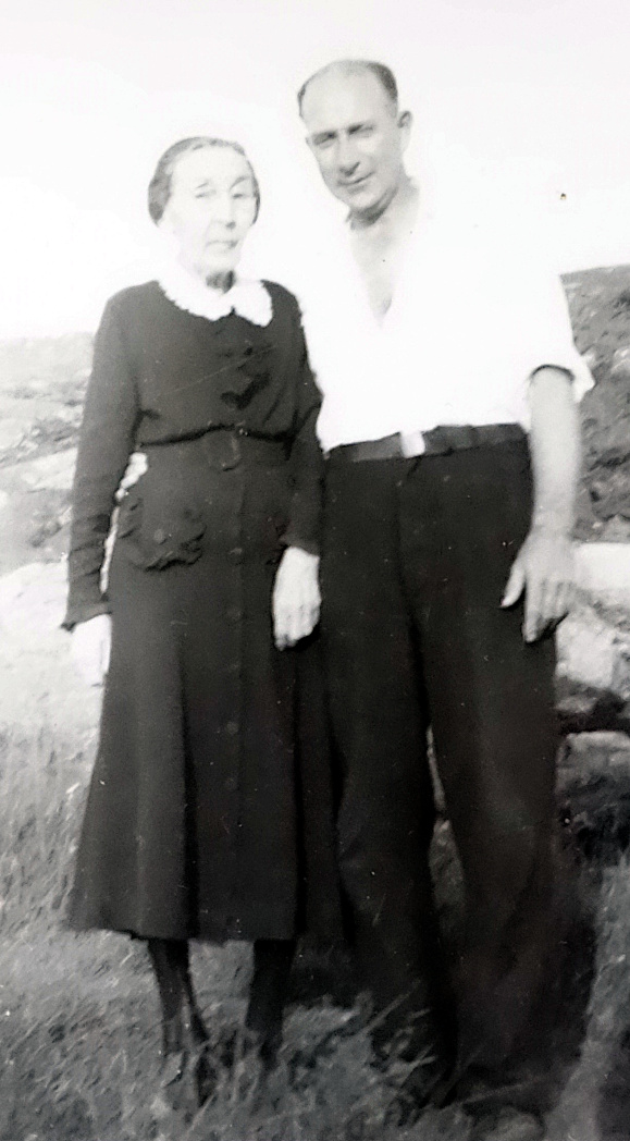 A man and elderly mother standing outside