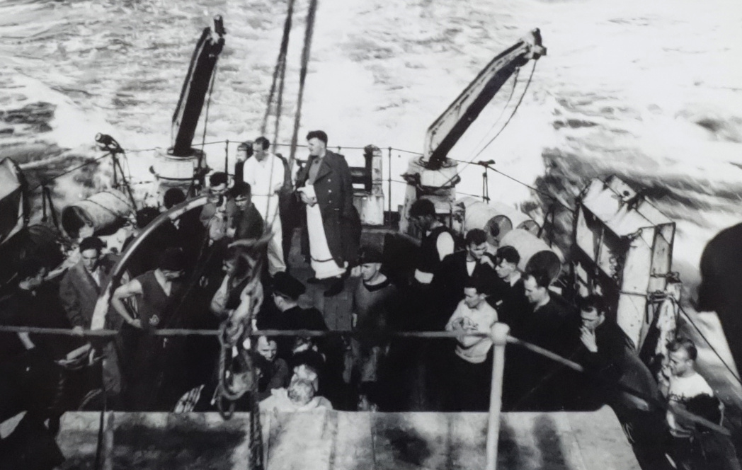 Group of men standing on stern deck of warship