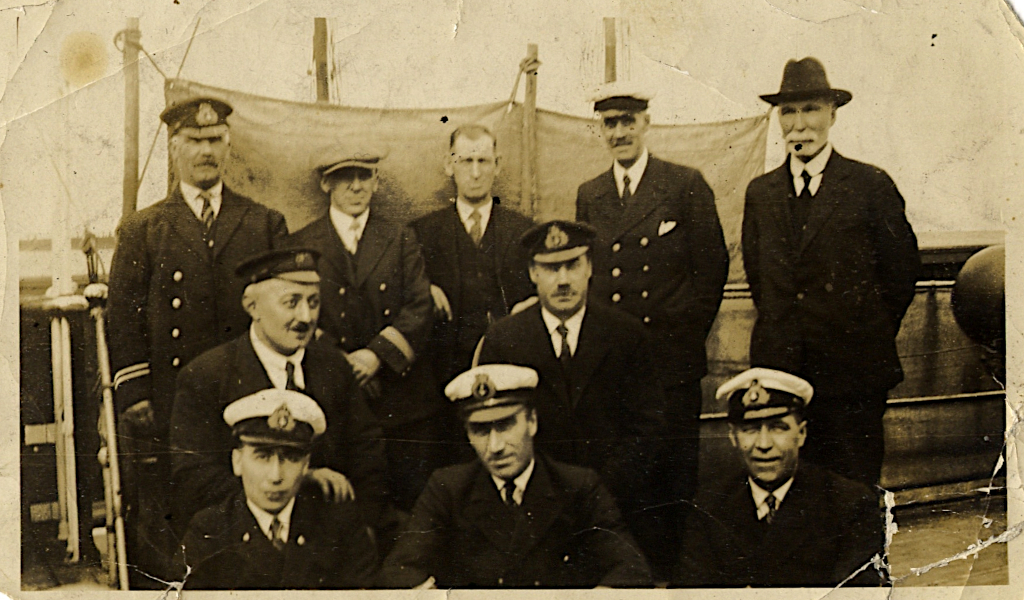 Group of men in naval uniforms or civilian clothes