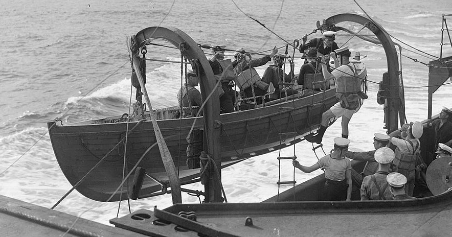 Sailors boarding a lifeboat on the side of a ship