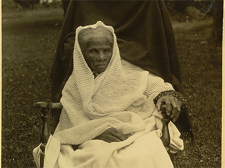 Historical portrait of Harriet Tubman in her later years, draped in a white shawl, reflecting her legacy as a humanitarian and community leader.