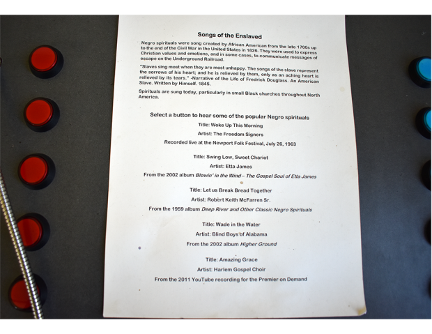 Interactive display page titled 'Songs of the Enslaved' with historical context about Negro spirituals and five red buttons to play different spiritual recordings.