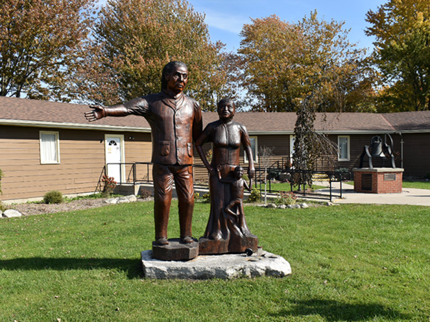 Wooden sculpture of a freedom-seeking family, carved by Grant Bone, located at the Josiah Henson Museum of African-Canadian History in Dresden, Ontario.