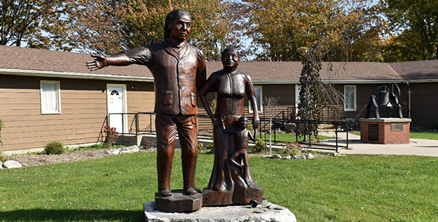 Sculpture en bois d'une famille cherchant la liberté, sculptée par Grant Bone, située au Musée Josiah Henson de l'histoire des Afro-Canadiens à Dresden, en Ontario.
