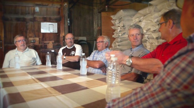 Six volunteers are sitting around a rectangular table talking.