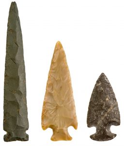 Three projectile points made of polished stone of various shapes.