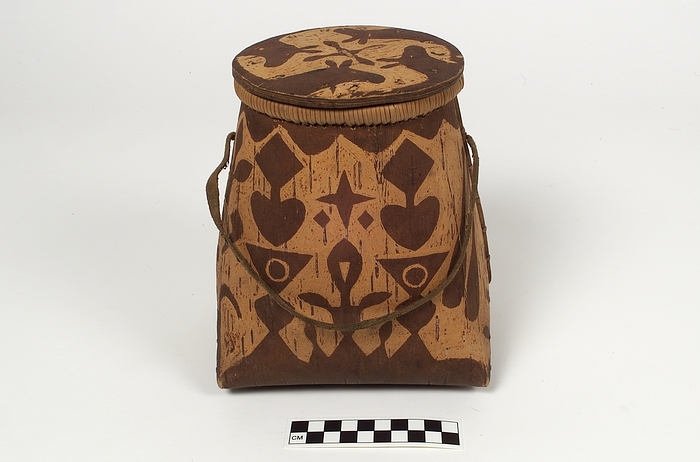 Rectangular shaped object with several patterns, with an opening at the top, a loop and a lid.