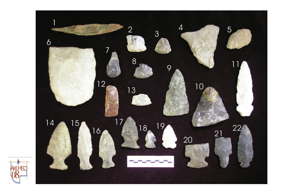 Artéfacts de tailles diverses en pierre et métal disposés sur un fond noir.