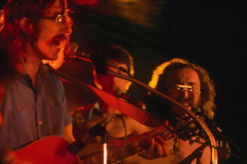 Close-up of three musicians, at the microphone during a musical performance.