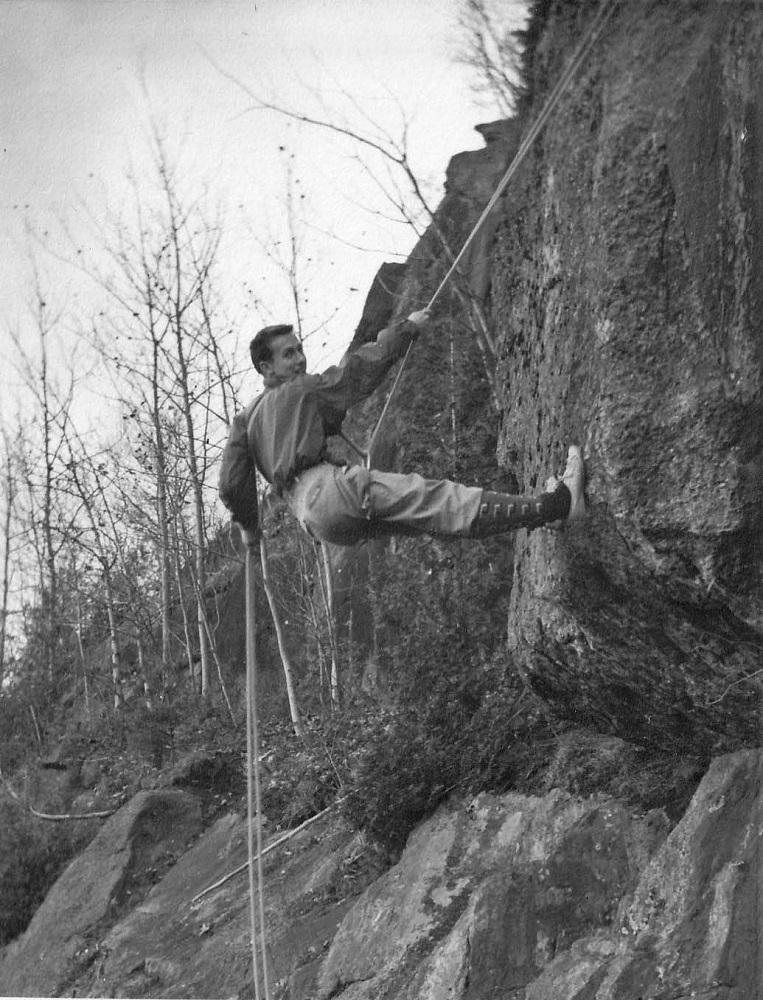 A climber on a rock face being held by a double rope.