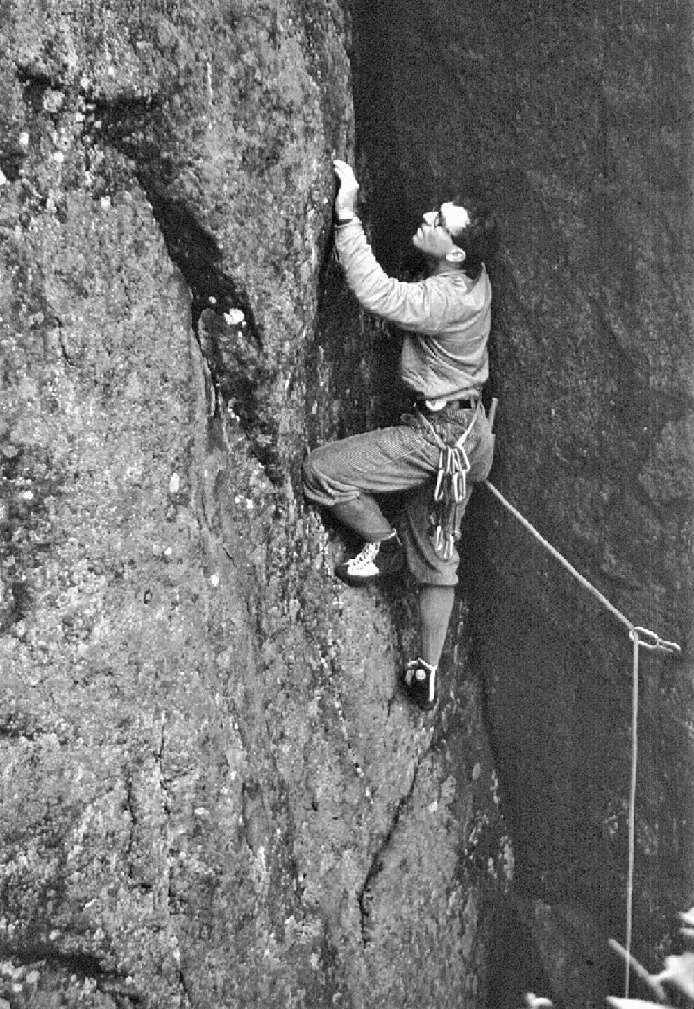 A climber on a rock face holding on to a rope.