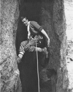 Un grimpeur se tenant par les mains et les pieds dans la crevasse d’une paroi rocheuse.