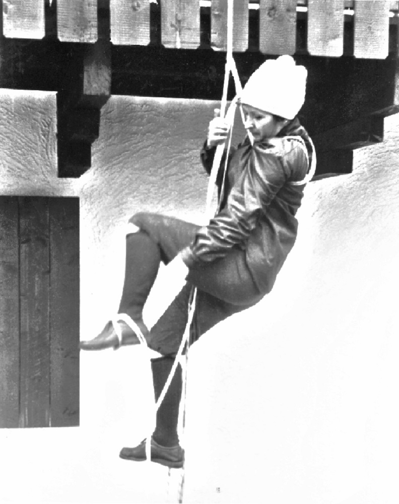 A young female novice climbing on a rope attached to a beam at Auberge le Rouet in Val-David.
