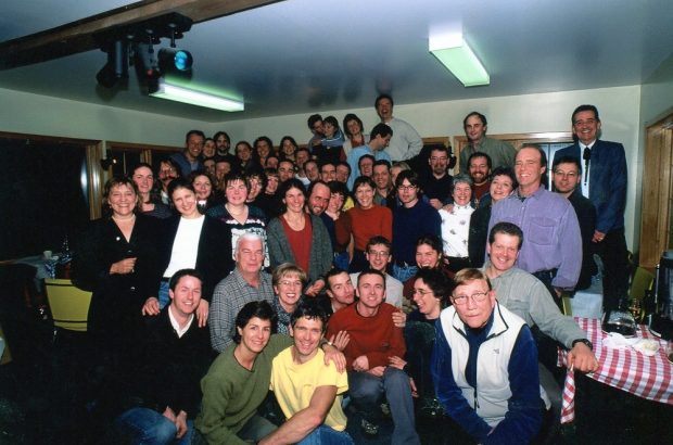 A group photo of about 40 people during a celebration in a large room.