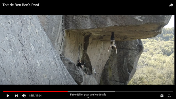 Man hanging by his feet in a rock roof.