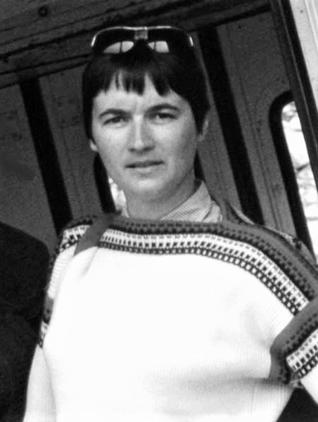 Close-up of a young woman with short hair wearing a light sweater.