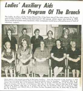 Article de journal noir et blanc titré « Ladies’ Auxiliary Aids In Program Of The Branch » et un texte de 50 mots qui décrit la photographie jointe, sur laquelle on peut voir 10 femmes, dont cinq assises sur la rangée du devant et cinq autres femmes debout à l’arrière (les noms de ces personnes sont joints).