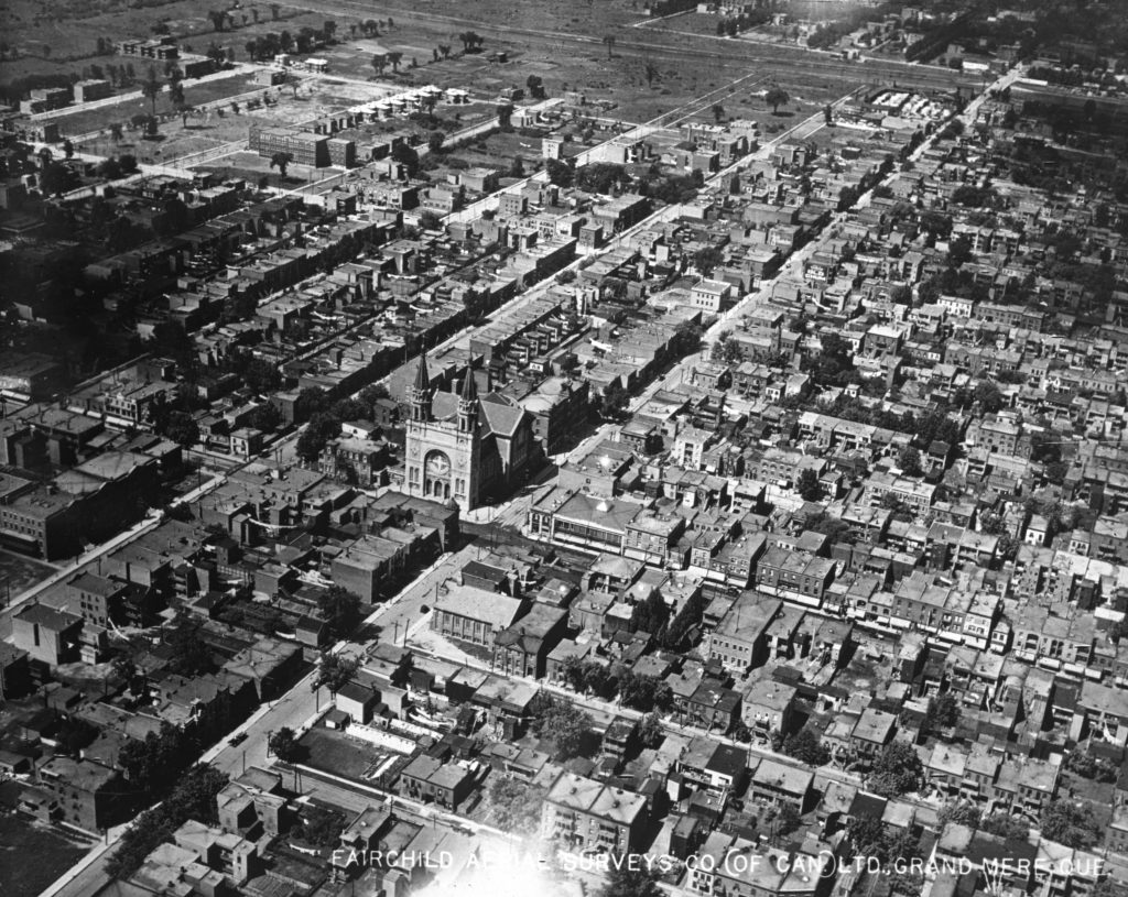 Oblique black and white aerial photograph of the roads and buildings of Verdun’s most urbanized area. The streets are rectilinear and intersect at right angles.