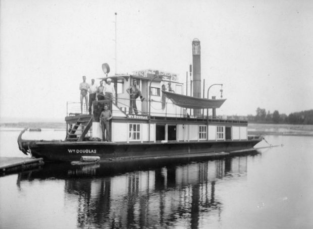 Several men pose for the camera on the upper and lower decks of the William Douglas tug boat.