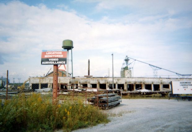 A sign at the entrance to a deserted mill site warns that the location is monitored by video surveillance.