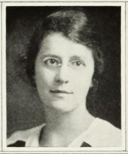 A black and white portrait of a woman in glasses.