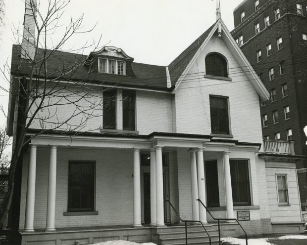 A black and white photograph of a two story building.