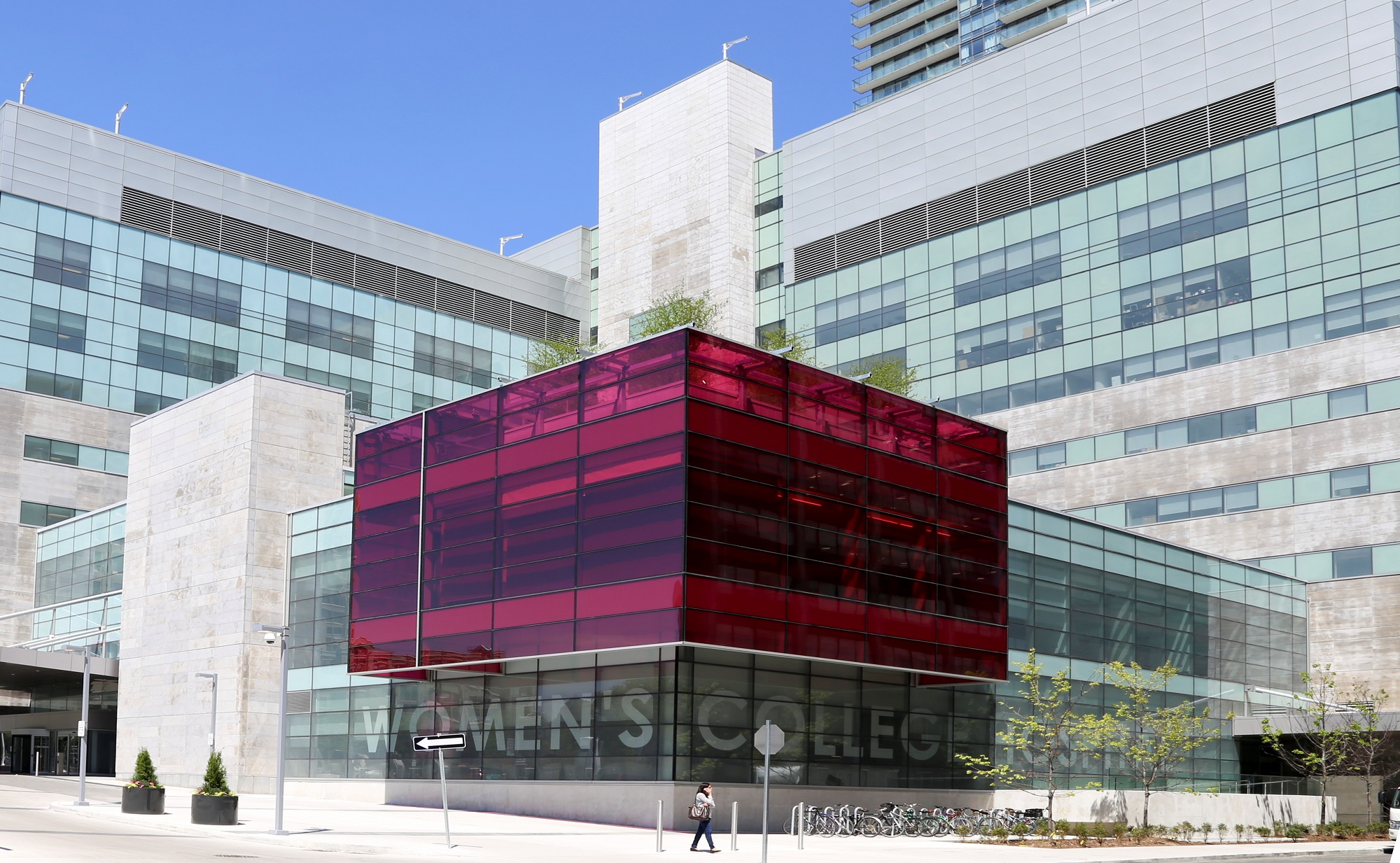 A coloured exterior photo of Women's College Hospital; the building features a large pink glass cube.