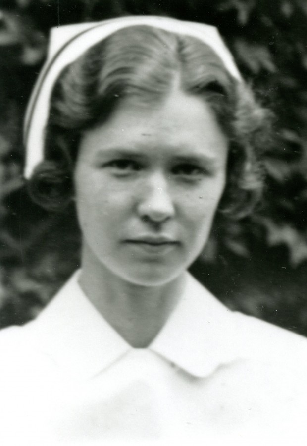 A young woman wearing a nurses' cap with black band poses for a formal portrait.