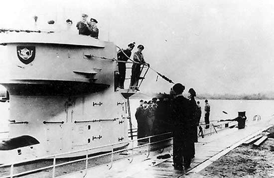 photo of German U-boat and crew moored at a wharf