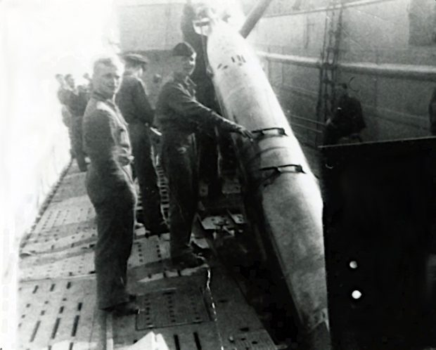 photo of Navy sailors loading a torpedo into a German submarine