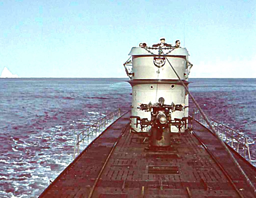 photo of German submarine at sea with iceberg in the background