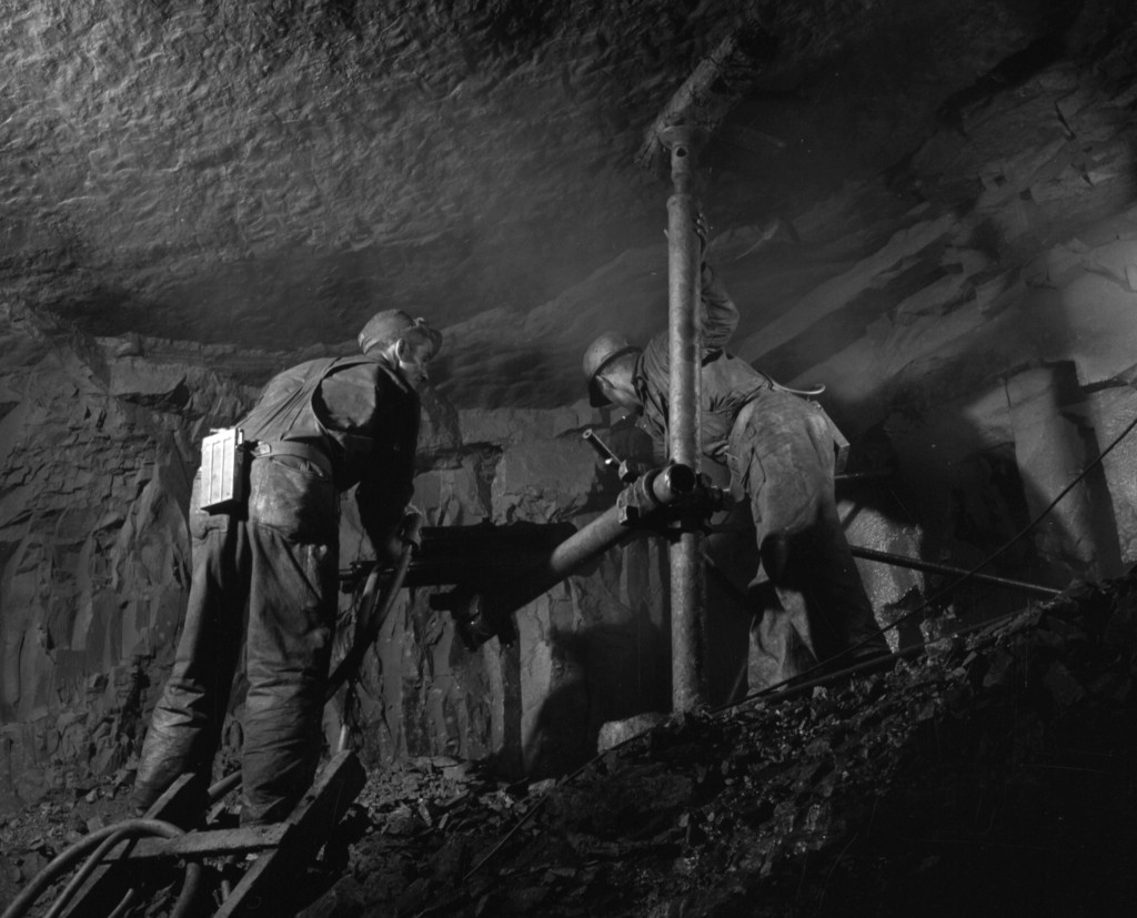 two workers operating a rock drill in a mine shaft at Bell Island