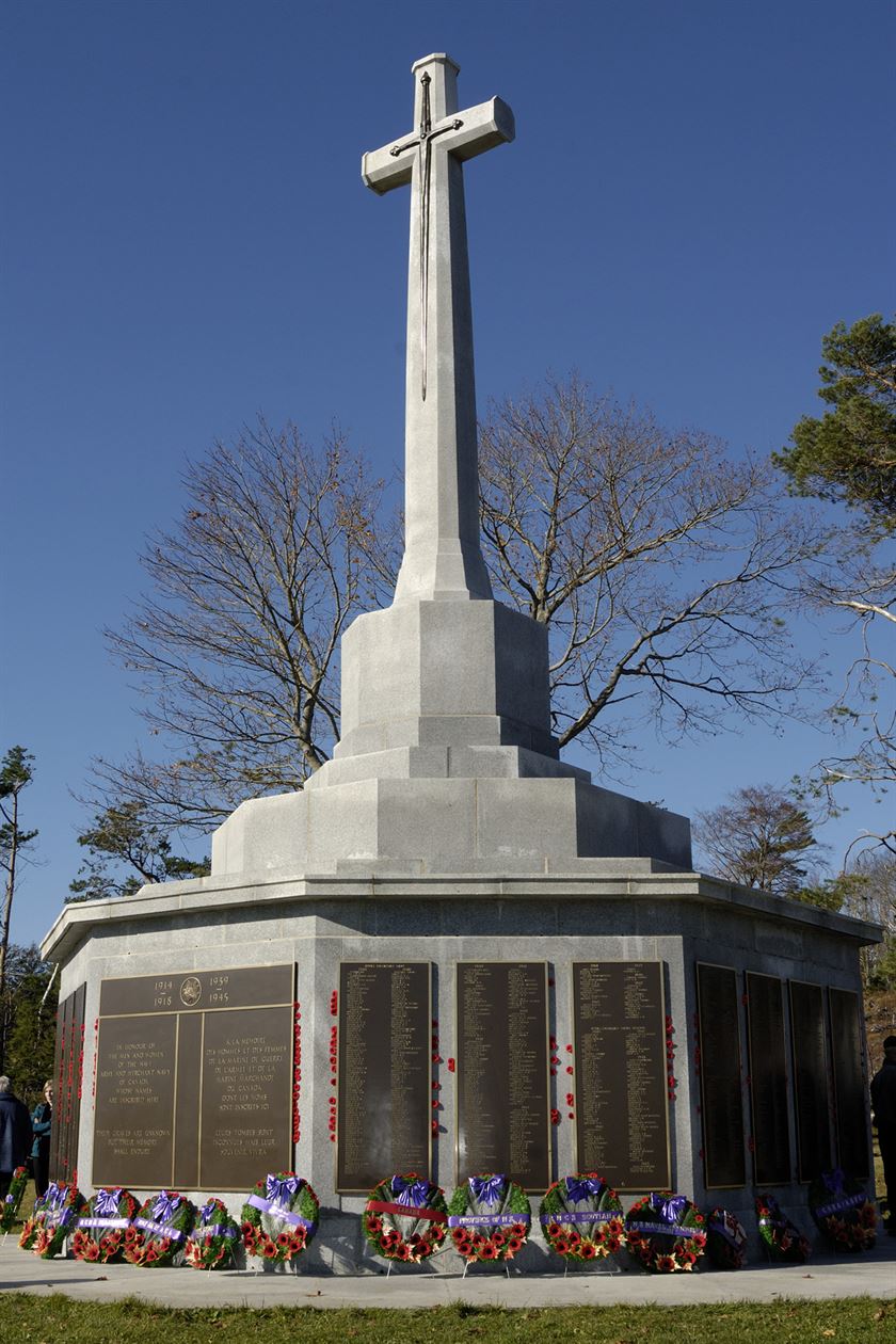 monument with a large stone cross above bronze plaques listing the names of Canadian war dead