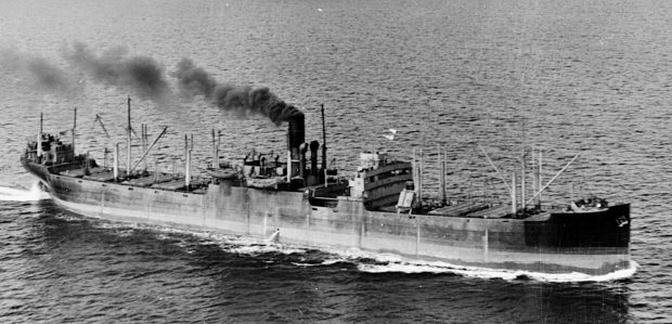 a large steel cargo ship at sea with a black plume of coal smoke from the funnel