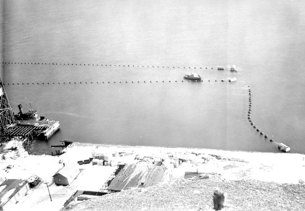 Photo showing ore loading pier on Bell Island surrounded by anti-torpedo netting