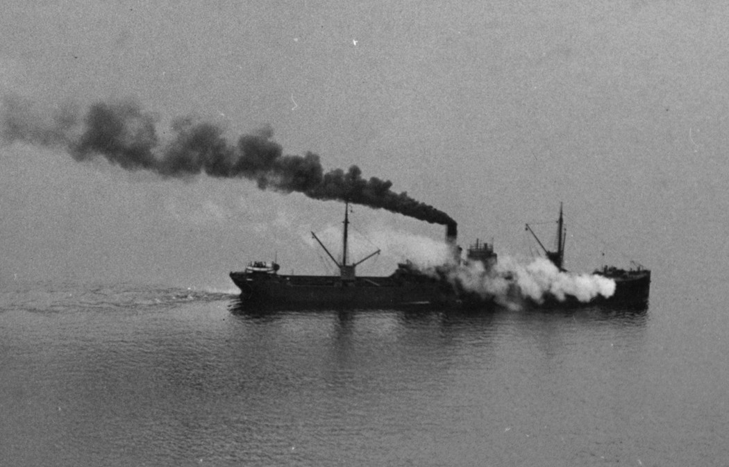 Steamship at sea with black plume of coal smoke from funnel