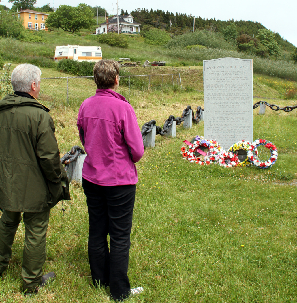 Two people standing in front of a stone monument