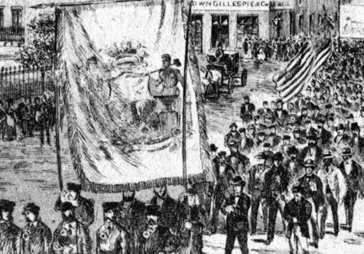 A cropped version of the cover of the Canadian Illustrated News from June 8 1872 depicts the parade of workers on May 15th 1872. There are dozens of spectators watching from the sidewalks as the parade of workers carry large banners and flags through the centre of the street.
