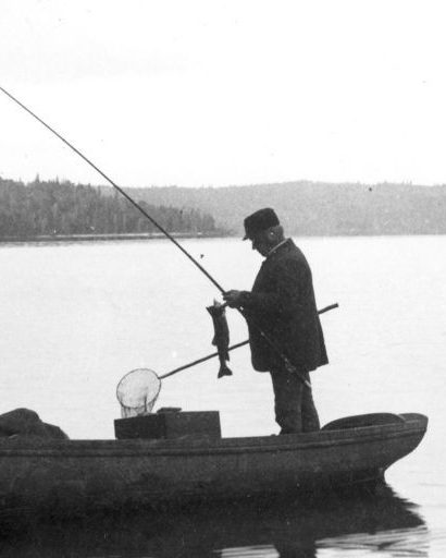 Black and white photo of fishermen in a steamboat on lac Édouard.
