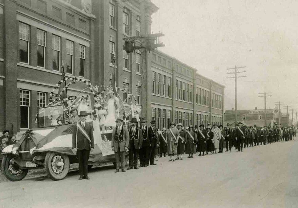 Parade float and procession in front of the Fernie Public School