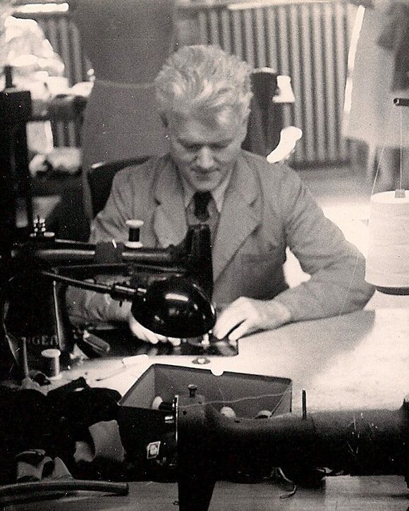 Man seated at sewing machine