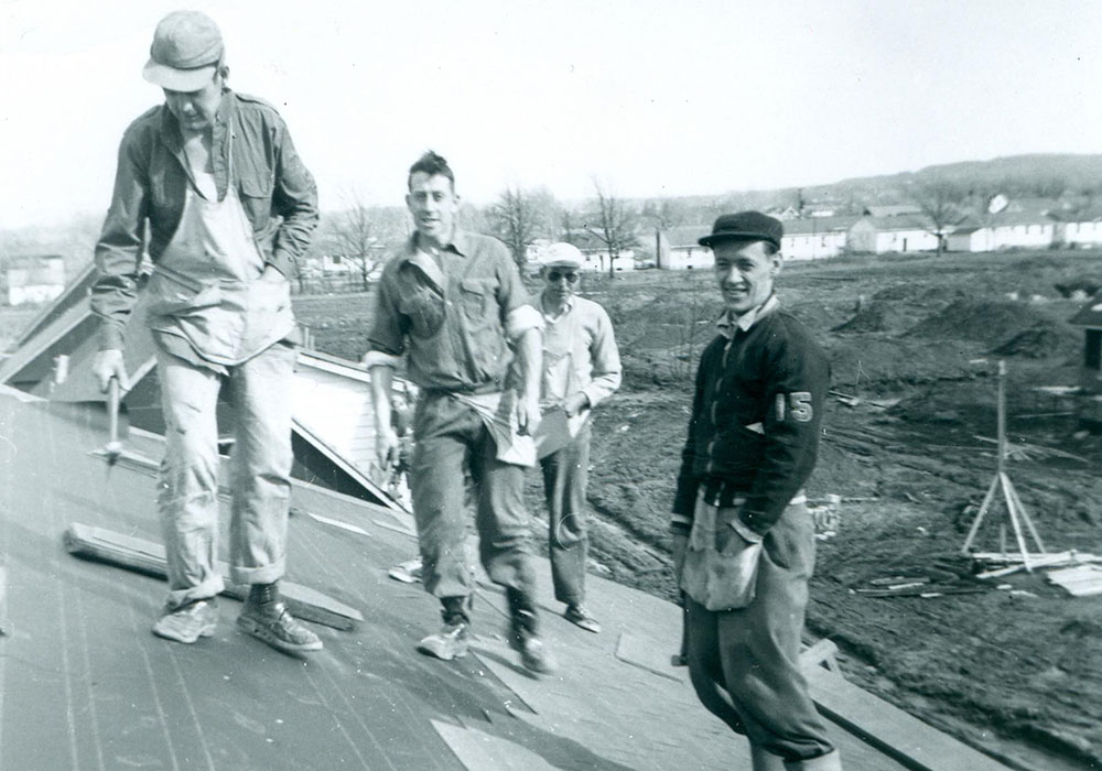 Black and white photograph of a group of four men on a roof.
