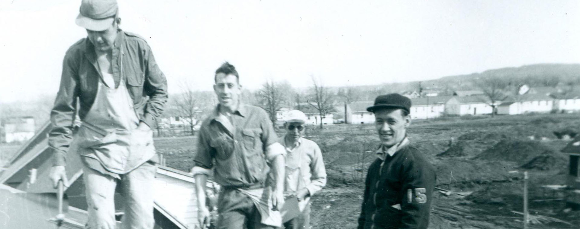 Black and white photograph of a group of four men on a roof.